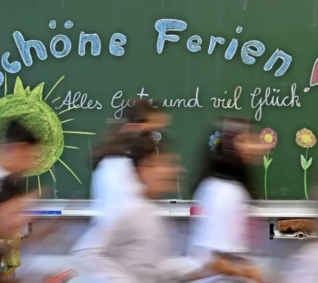 Schöne Ferien! Kinder in Schleswig-Holstein freuen sich auf die Herbstferien. Tafel mit Sonne, Herz und Blumen.