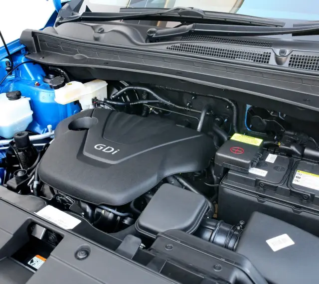 Silnik GDI w Kia Sportage (2015) z widocznym akumulatorem i płynami.