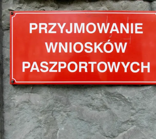 Czerwona tablica informuje o przyjmowaniu wniosków paszportowych. Czy żona może odebrać paszport męża? Sprawdź w urzędzie.