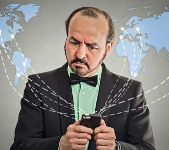 Mężczyzna w garniturze z telefonem, zastanawia się, co to roaming. Mapa świata z połączeniami sugeruje globalną sieć.