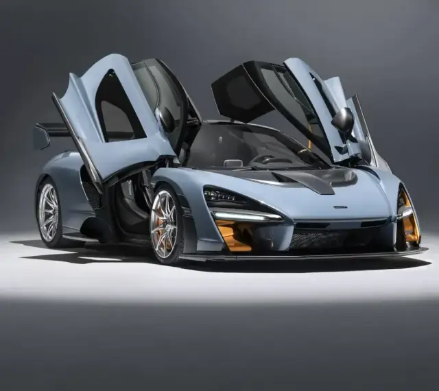 Niebieski McLaren Senna z otwartymi drzwiami, gotowy do startu.