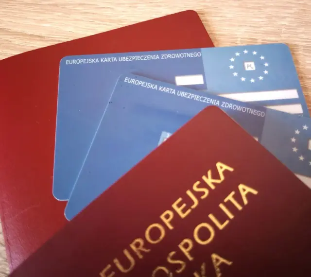 Czerwony paszport i dwie niebieskie karty EKUZ Konin, gotowe na podróż po Europie.