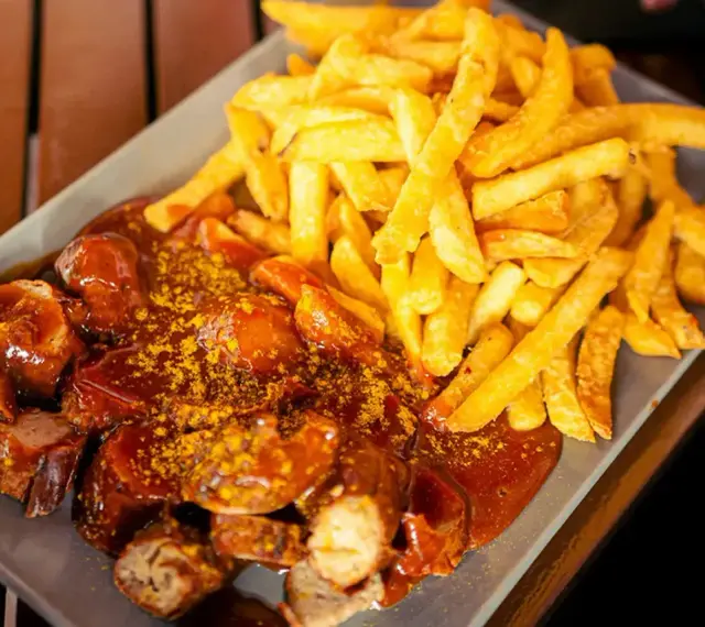 Currywurst z frytkami, klasyka, co zjeść w Berlinie. Pyszne danie na talerzu.