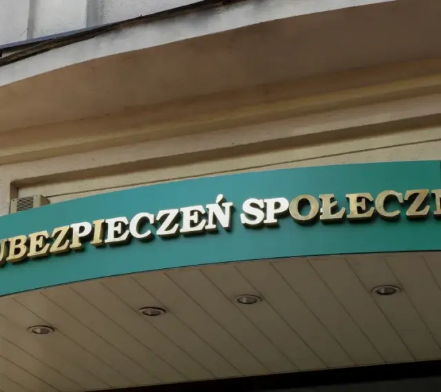 Złoty napis "ZAKŁAD UBEZPIECZEŃ SPOŁECZNYCH" na zielonym tle.