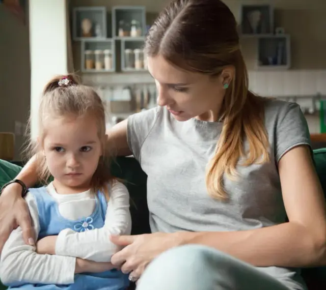 Mama próbuje uspokoić obrażone dziecko, które nie chce słuchać.