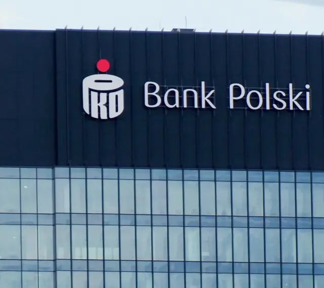 Logo PKO BP na ciemnym budynku. Widoczny napis "Bank Polski".