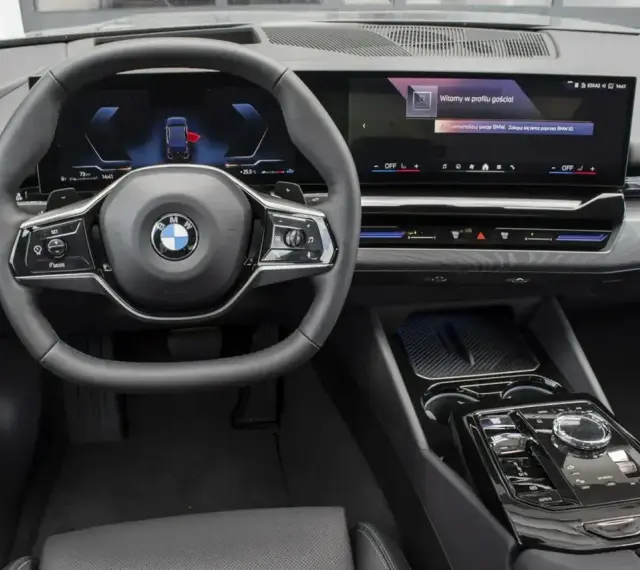 Wnętrze BMW 520d xDrive z nowoczesnym ekranem i kierownicą.