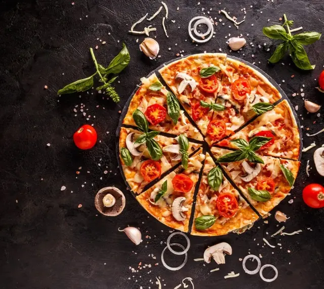 Pyszna pizza z pomidorkami, pieczarkami i bazylią. Zastanawiasz się, ile kcal ma pizza? To zależy od składników!