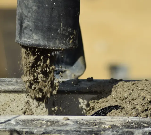 Beton wylewany z rury, rozpoczyna się proces jego wiązania. Czas, ile schnie beton, zależy od wielu czynników.