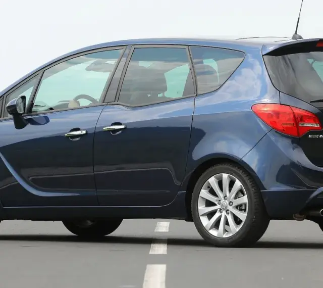 Ciemnoniebieski Opel Meriva B z polskimi tablicami WE 3428V na drodze.
