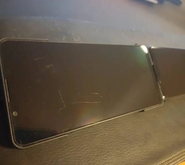 Dwa smartfony leżą obok siebie. Ekran jednego z nich, wykonany z Gorilla Glass Victus 2, nosi ślady zarysowań.