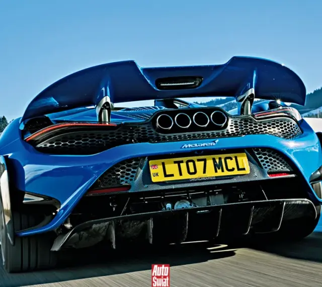 Niebieski McLaren 765LT z czterema końcówkami wydechu pędzi po ośnieżonej drodze w górach.