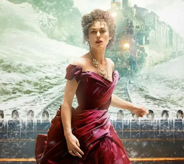 Anna Karenina w bordowej sukni, na tle pędzącego pociągu i śnieżnego krajobrazu. Obok stoją mężczyźni w strojach z epoki.