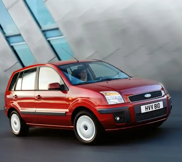 Czerwony Ford Fusion 1.4 benzyna w ruchu miejskim. Elegancka sylwetka i nowoczesny design.