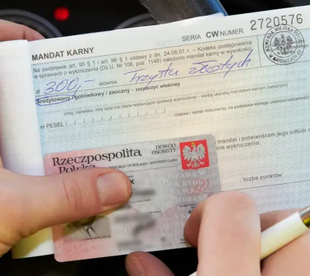 Ręka trzyma mandat karny na 300 zł i dowód osobisty. Ktoś wypełnia dokument, być może to mandat za parkowanie.