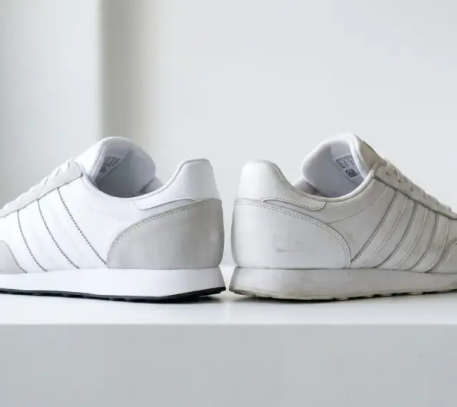 Dwa białe buty sportowe Adidas, jeden czysty, drugi lekko zabrudzony. Jak sprawdzić oryginalność? Zwróć uwagę na detale.