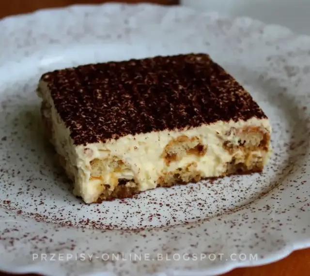 Pyszne tiramisu, czyli zabajone, na białym talerzu, posypane kakao.