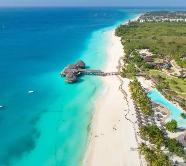 Rajskie plaże Zanzibar w lipcu: turkusowa woda, biały piasek, palmy i luksusowe bungalowy na wodzie. Idealne miejsce na wakacje.