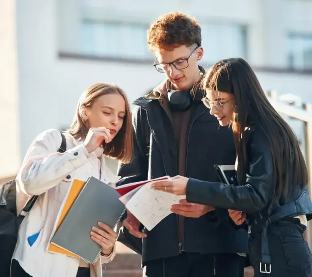 Trzech studentów dyskutuje o notatkach, zastanawiając się nad statusem ucznia a umową zlecenie.