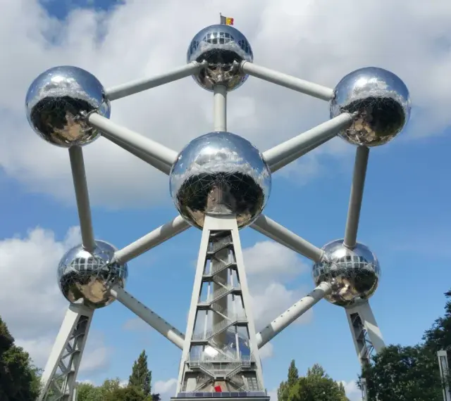 Atomium, symbol Brukseli, lśni w słońcu. To miejsce, gdzie jest Bruksela, przyciąga turystów.