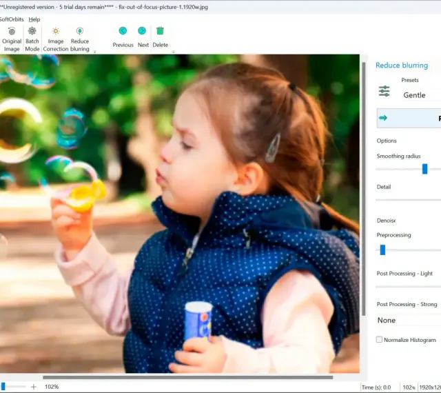 Dziewczynka dmucha bańki. Program Easy Photo Unblur pomaga jak wyostrzyć zdjęcie, oferując opcje redukcji rozmycia i poprawy detali.