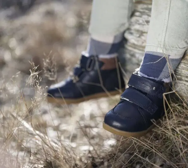 Granatowe, zimowe buty dziecięce na rzepy i sznurowadła, z futerkiem w środku. Wygodne i stylowe, idealne na jesienne i zimowe przygody. Różne marki butów oferują podobne modele.