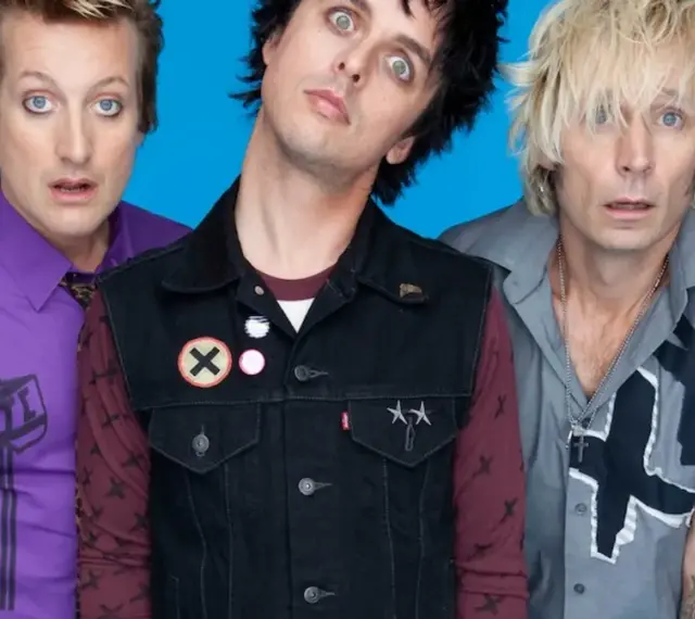 Trzech członków zespołu Green Day Polska z wyrazistymi minami na niebieskim tle.