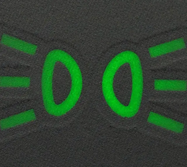 Zielony symbol świateł mijania na ciemnym tle.