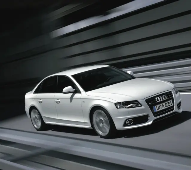 Białe Audi A4 B8 w ruchu, z rozmytym tłem. Wiele osób szuka audi a4 b8 opinie, by poznać jego zalety.