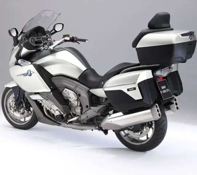 Srebrny motocykl BMW K1600GTL z kuframi i podnóżkami. Idealny do długich podróży, sprawdź jego bmw k1600gtl dane techniczne.