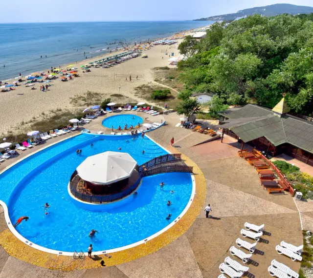 Słoneczny dzień w Albena Bułgaria. Ludzie odpoczywają na plaży i kąpią się w basenie z barem.