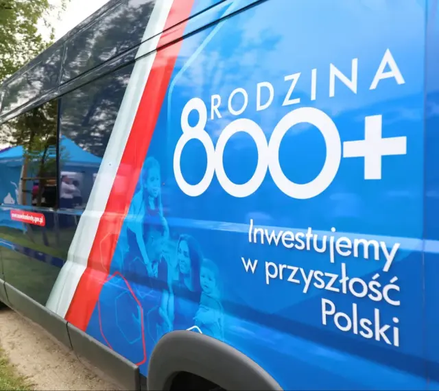Niebieski van z napisem "RODZINA 800+" i hasłem "Inwestujemy w przyszłość Polski". Widoczne zmiany w 800 plus.