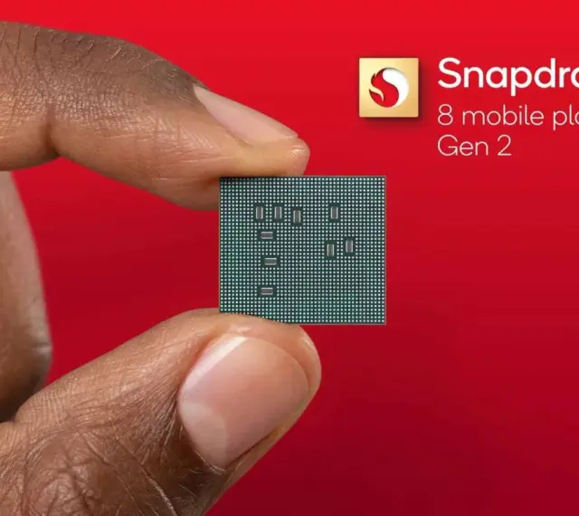 Palec i kciuk trzymają niewielki procesor. Obok widnieje logo Snapdragon 8 mobile platform Gen 2.