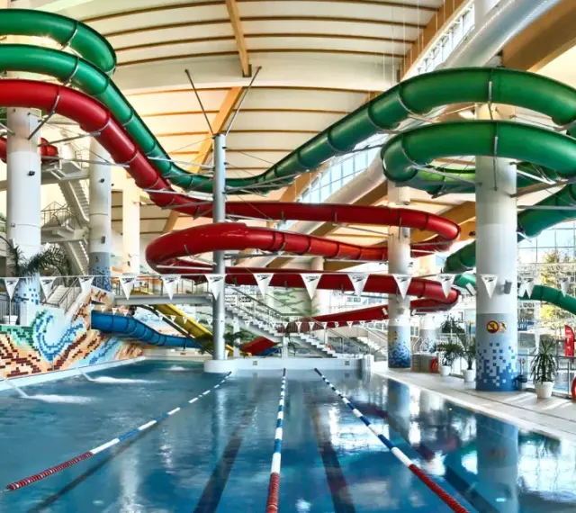 Wesoły aquapark z hotelem oferuje zjeżdżalnie w kolorach czerwonym i zielonym, basen i mnóstwo zabawy.
