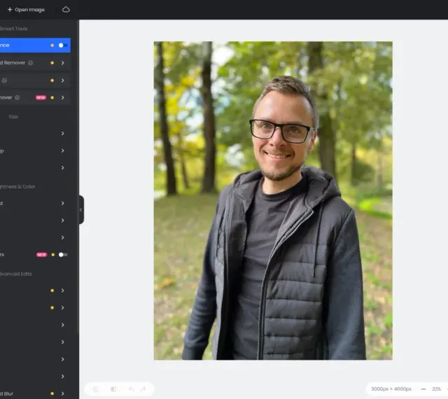 Program do obróbki zdjęć na komputer Fotor pozwala na edycję portretu mężczyzny w parku.
