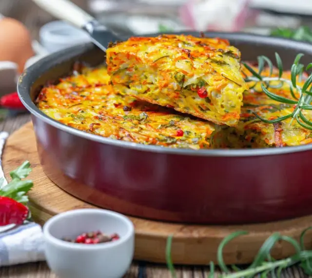 Pyszna keto kolacja w formie zapiekanki z warzywami i ziołami, podana w patelni.