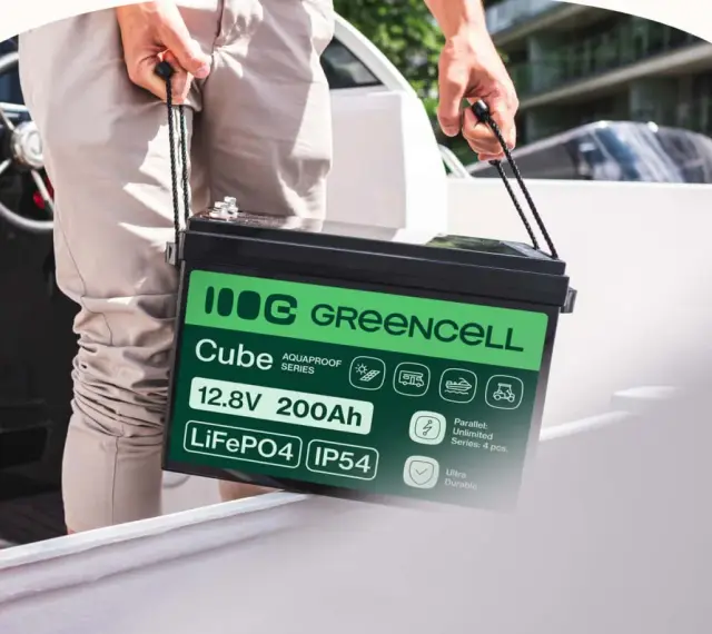 Mężczyzna niesie akumulator LiFePO4 12.8V 200Ah marki Greencell Cube. To jeden z rodzajów akumulatorów, idealny do łodzi, kamperów i wózków golfowych.