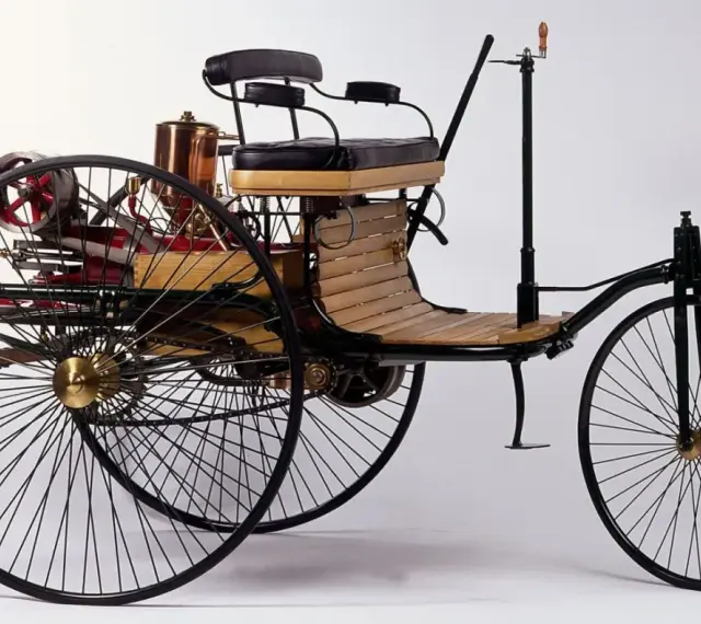 Tricykl Benz Patent-Motorwagen, pierwszy samochód na świecie, z drewnianym siedzeniem i miedzianym kotłem.