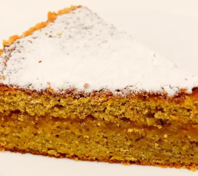 Wilgotne ciasto marchewkowe posypane cukrem pudrem. Idealne na deser, choć warto sprawdzić ciasto marchewkowe kcal przed zjedzeniem.