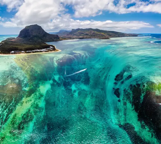 Widok z lotu ptaka na turkusowe wody i góry Mauritiusa. Marzysz o podróży? Mauritius wiza to pierwszy krok do raju.