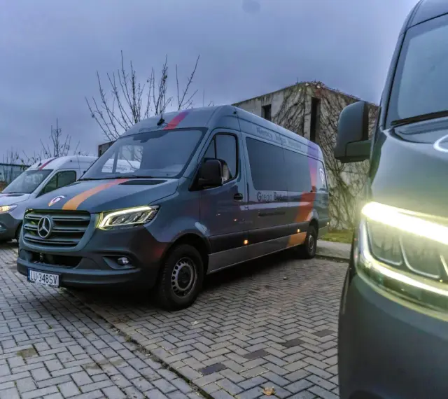Busy Chełm Zamość przez Krasnystaw. Kilka busów "Grego Bus" zaparkowanych na kostce brukowej, gotowych do podróży.