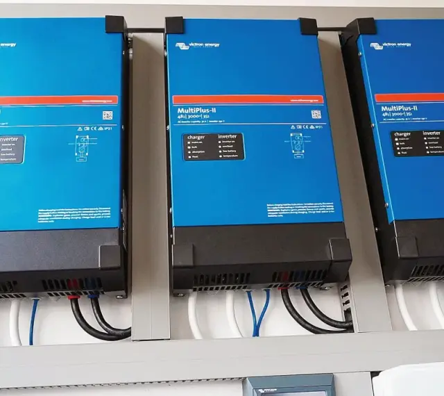 Trzy niebieskie falowniki Victron Energy MultiPlus-II zamontowane obok siebie. Od września 2026 r. każdy blok musi posiadać certyfikowany magazyn energii.