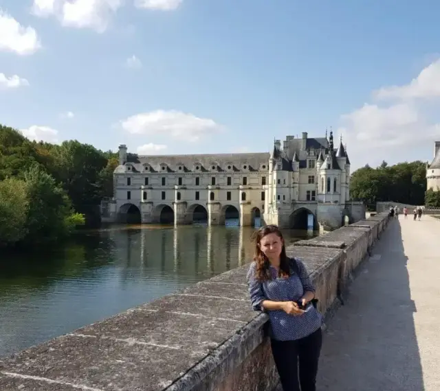 Kobieta na moście przed zamkiem Chenonceau, nad rzeką Cher, dopływem najdłuższej rzeki Francji, Loary.