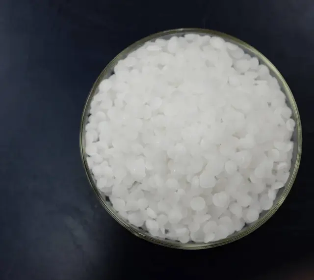 Schale mit weißen Pellets, die Natriumhydroxid darstellen.