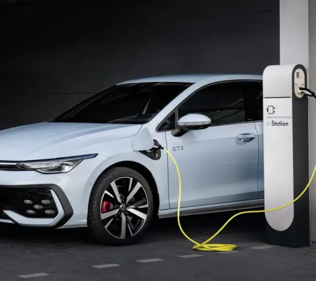 Jasnoniebieski Volkswagen Golf GTE podłączony do stacji ładowania e-Station.