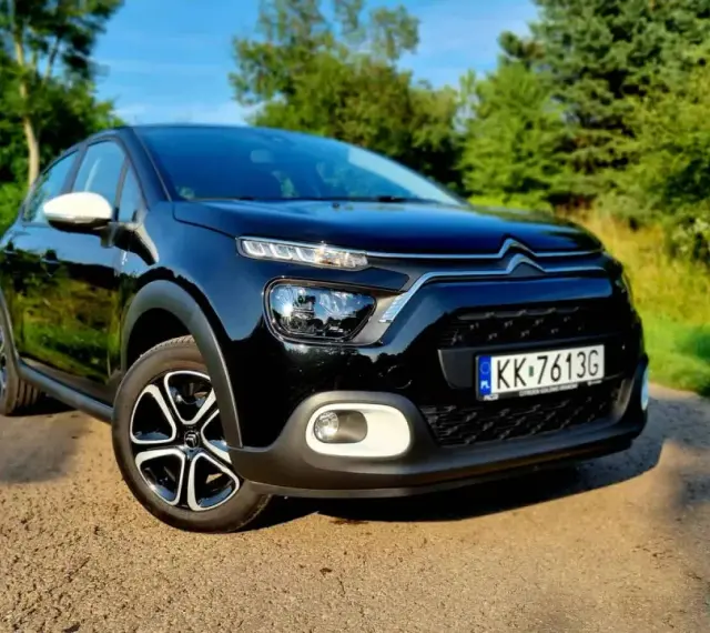 Czarny Citroen C3 na tle zieleni. Sprawdź atrakcyjną citroen c3 cena i wybierz swój wymarzony samochód.
