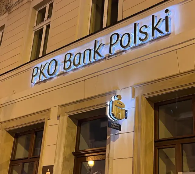 PKO Bank Polski oferuje atrakcyjne pko lokaty długoterminowe. Elegancka fasada banku nocą.
