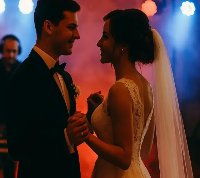 Para młoda tańczy przy dźwiękach wzruszających piosenek na wesele. W tle DJ w słuchawkach.