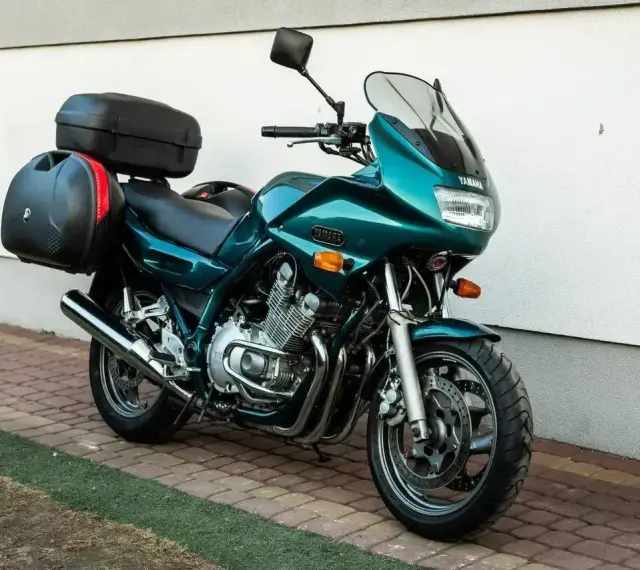 Zielony motocykl Yamaha XJ 900 z kuframi, gotowy na dalekie podróże.