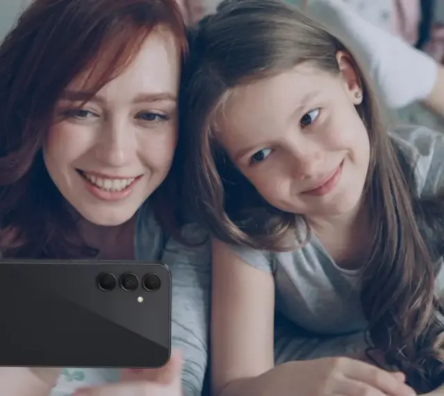 Mama i córka robią selfie telefonem. Od ilu lat można mieć telefon? Odpowiedź zależy od rodziców i dziecka.
